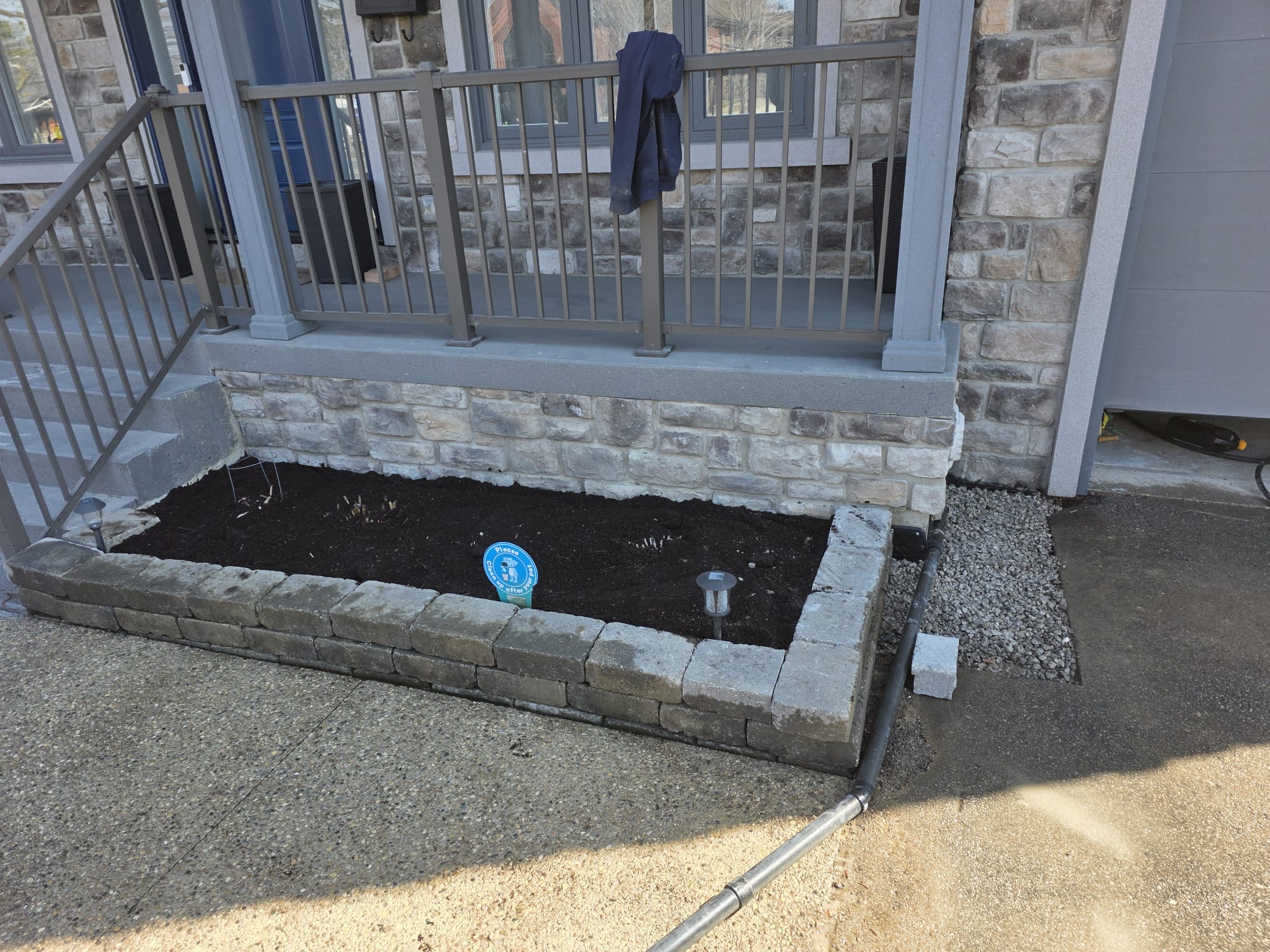 Front of a house after waterproofing is completed, showing gravel and pit closed off ad a garden on top